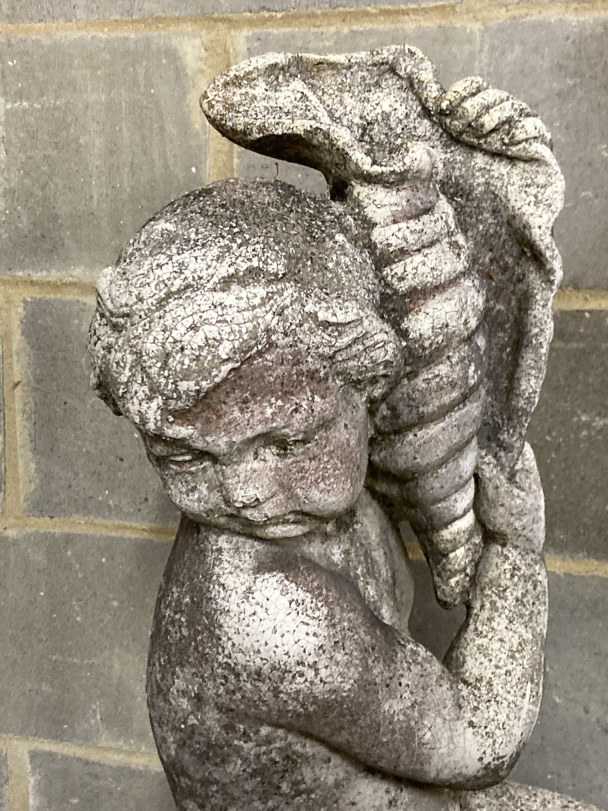 A reconstituted stone garden figure on plinth, boy with a sea shell, height 154cm